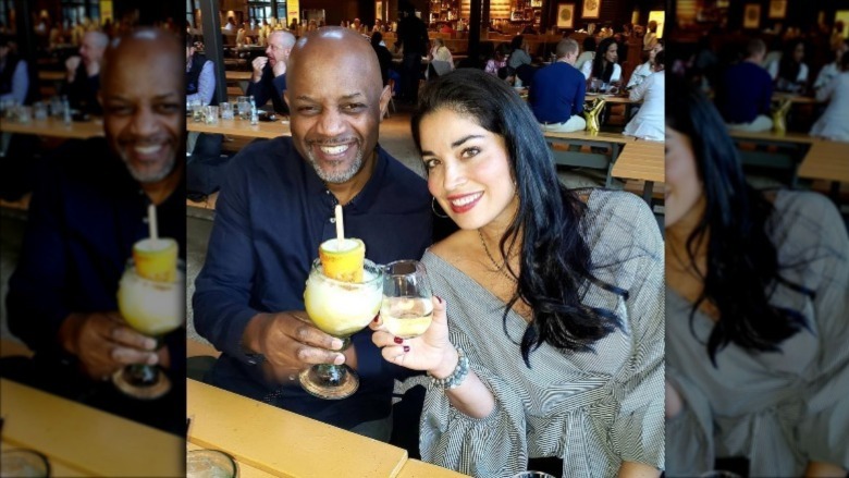 Pastor Calvin Roberson and Dr. Viviana Coles toasting with drinks in a bar