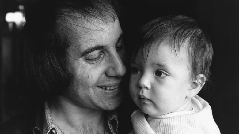 Paul Simon holds his son Harper