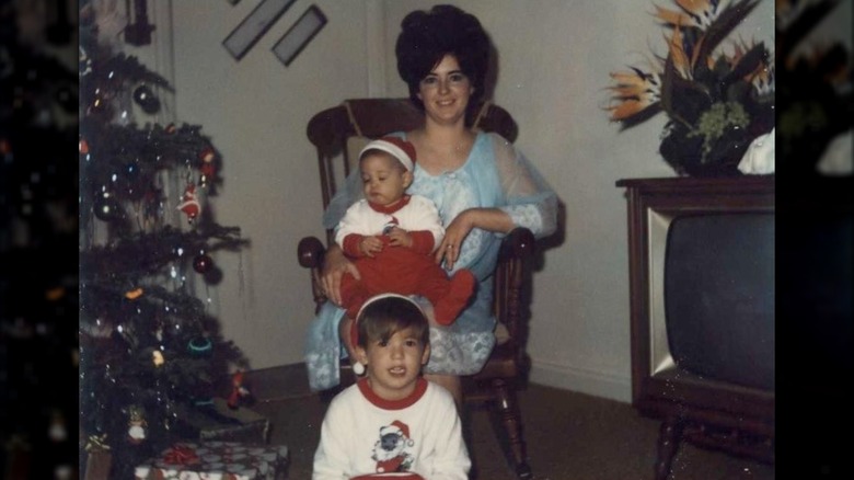 Paula Deen and sons seated beside Christmas tree