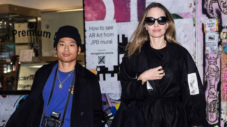 Pax Jolie-Pitt walking beside Angelina Jolie