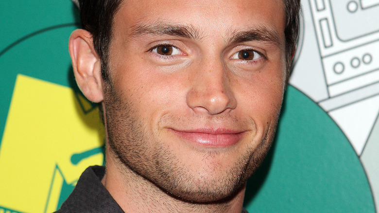 Penn Badgley with a slight smile