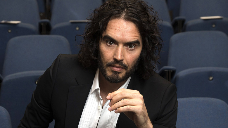 Russell Brand posing in auditorium 