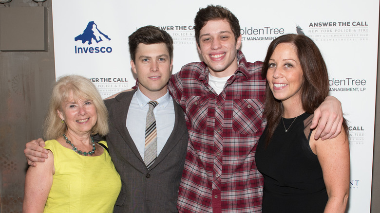 Pete Davidson, Colin Jost, and their mothers posing for a picture