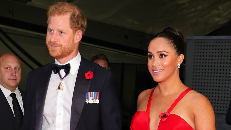 Prince Harry in tux and Meghan Markle in red gown