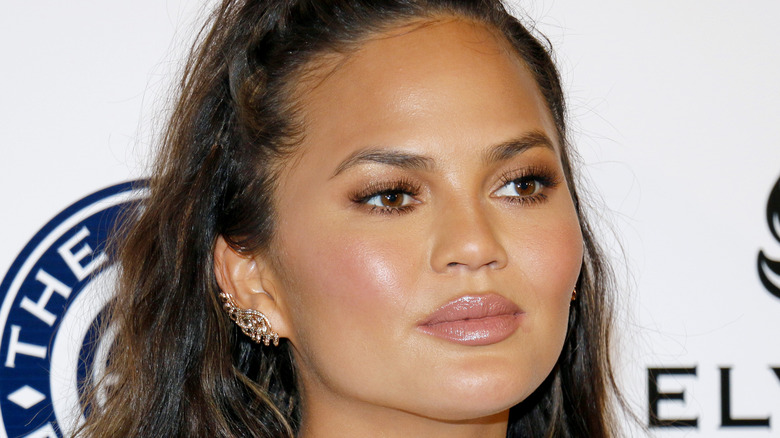 Chrissy Teigen smirks on red carpet