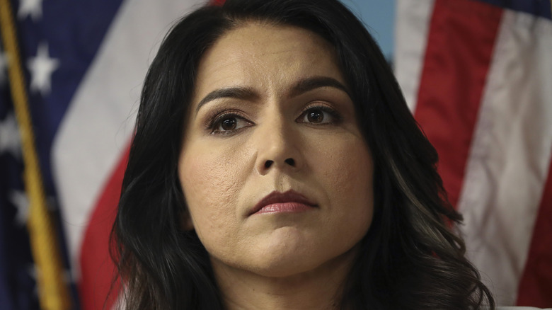 Tulsi Gabbard in front of a flag