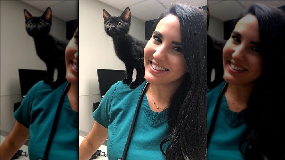 Dr. Jackie Denaus smiling with a cat on ther shoulder 