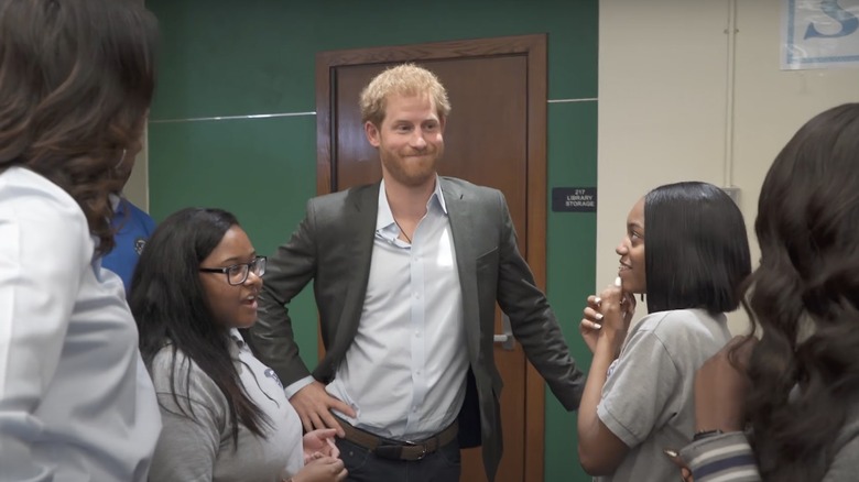 Prince Harry speaking with students