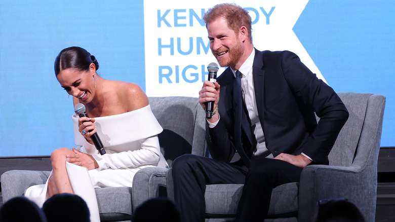 Meghan Markle and Prince Harry laughing on stage