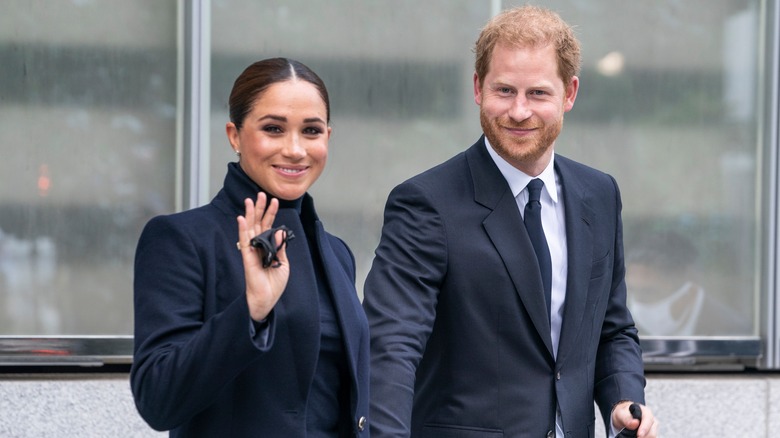 Meghan Markle and Prince Harry waving and smiling