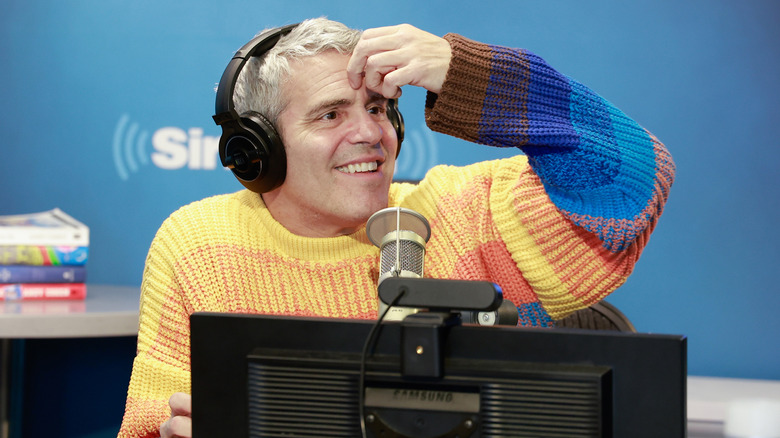 Andy Cohen touching forehead