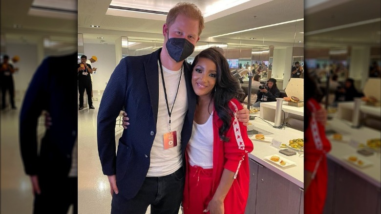 Mickey Guyton with arm around Prince Harry