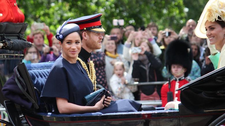 Prince Harry and Meghan Markle riding  in carriage