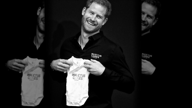 Prince Harry holding baby vest