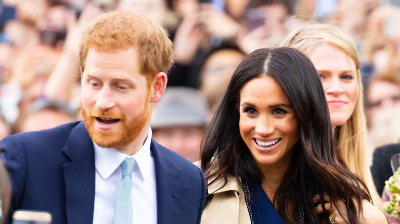 Prince Harry and Meghan Markle in a crowd of fans