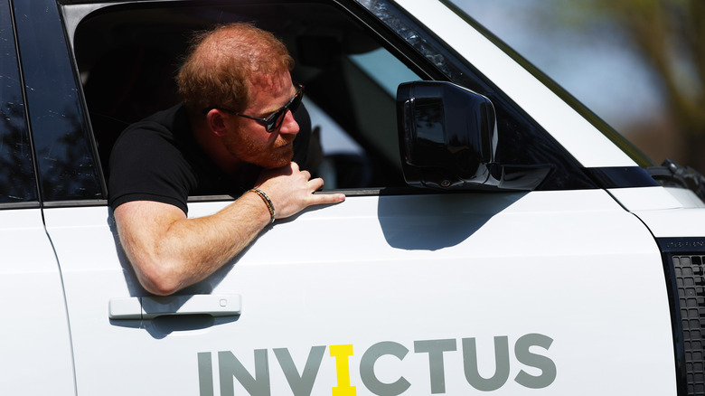 Prince Harry riding a car