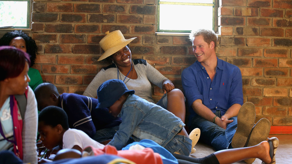 Prince Harry laughing with a group of people in Lesotho