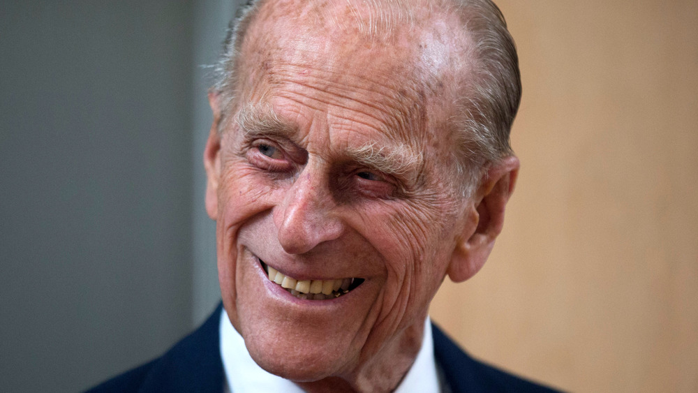 Prince Philip laughs at a joke during a public outing