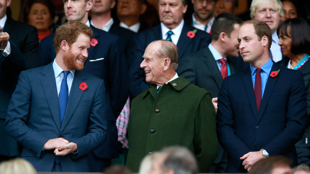 Prince Harry and Prince Philip laughing alongside Prince William