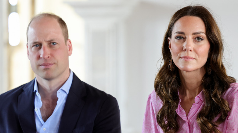 Prince William and Kate Middleton sitting side by side looking glum