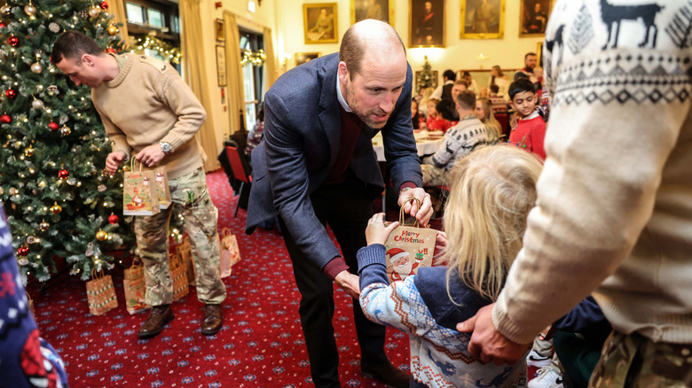 Prince William giving a gift to a child