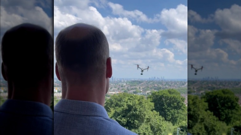 Prince William, back of his head, flying a drone over trees, 2021 photo