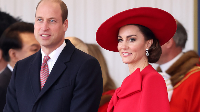 Prince William and Kate Middleton stand together in formal wear