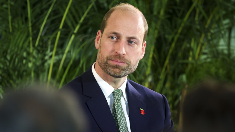 Prince William wearing a blue suit and green tie