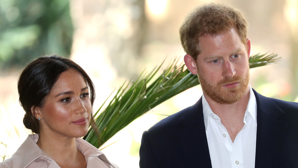 Prince Harry and Meghan Markle with serious expressions