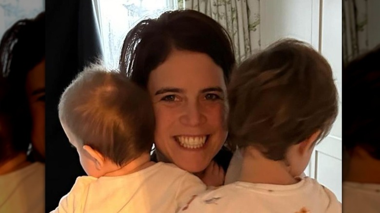 Princess Eugenie holding her two sons and smiling