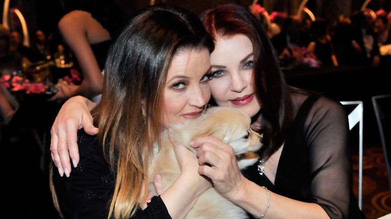 Lisa Marie and Priscilla Presley holding dog