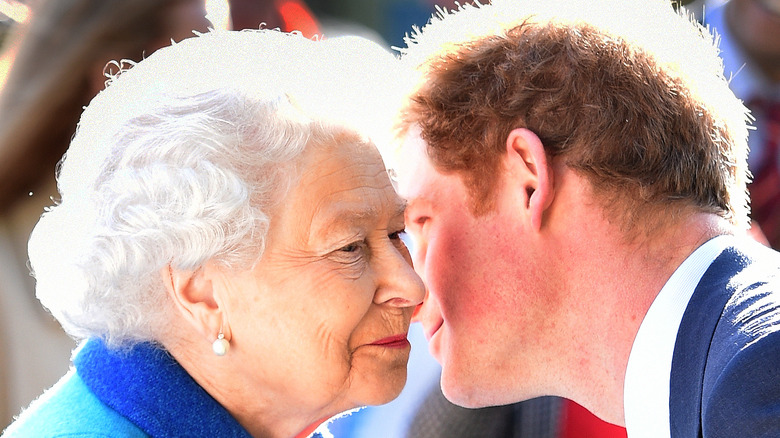 Prince Harry whispers to smiling Queen Elizabeth II in 2015