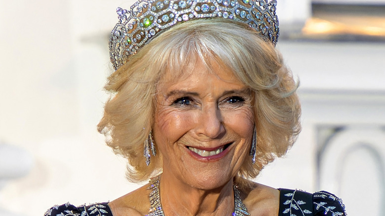 Queen Camilla smiling and wearing a diamond tiara