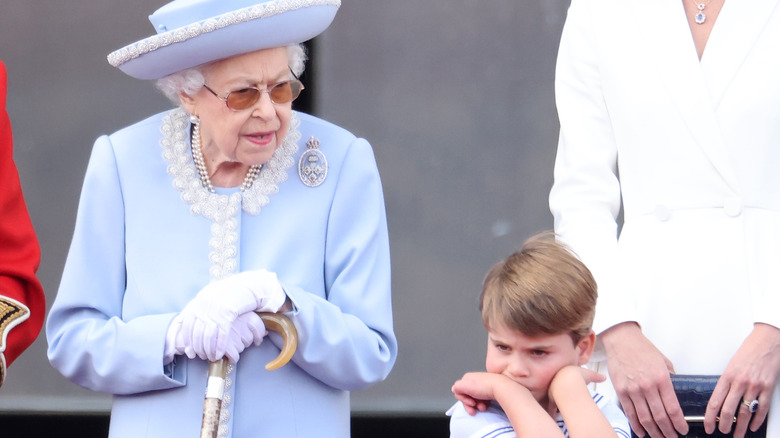 Queen Elizabeth in blue with scowling grandson