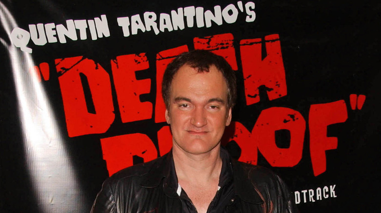 Quentin Tarantino behind a Death Proof poster