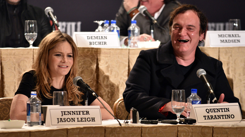 Jennifer Jason Leigh and Quentin Tarantino seated during a panel discussion