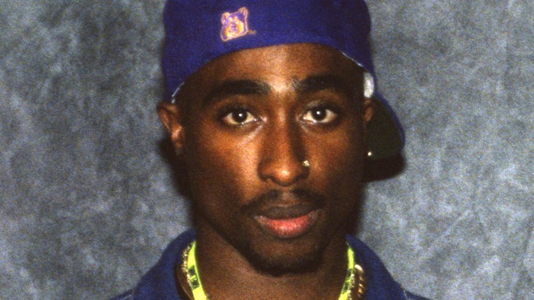 Tupac Shakur wearing a blue cap