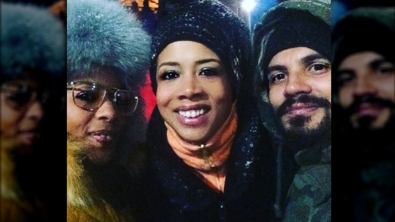 Kelis and Mike Mora smiling with a friend