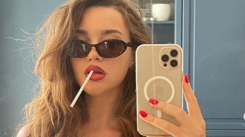 Emily Gorelik selfie in sunglasses with cigarillo in mouth 