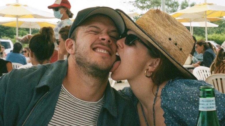 Jimmy Tatro being licked on the cheek by Zoey Deutch