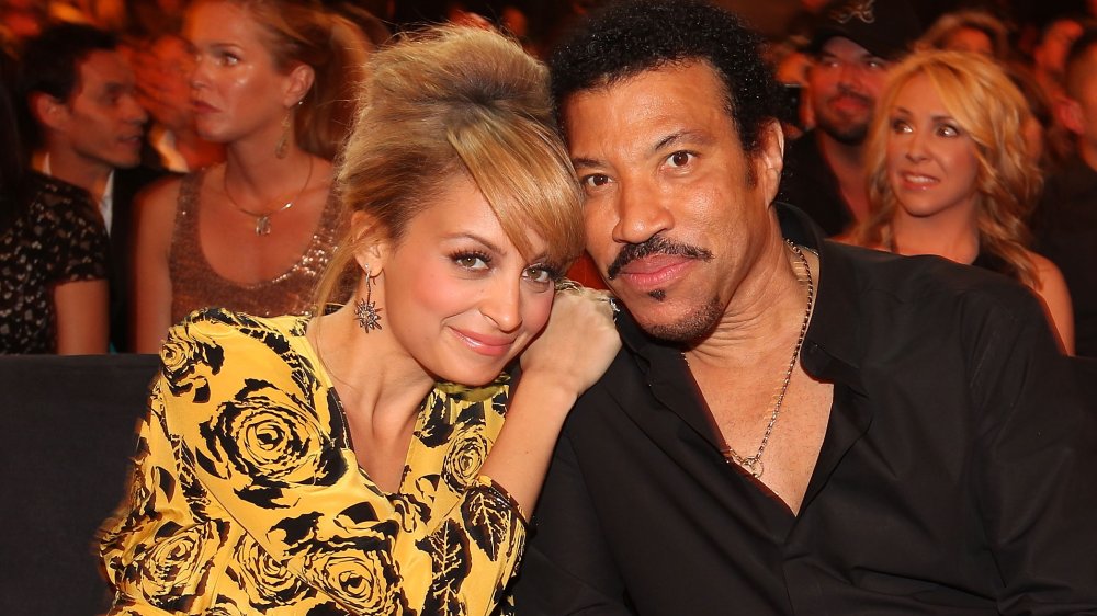 Nicole Richie hugging Lionel Richie while seated