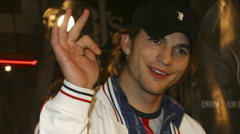 Ashton Kutcher laughing with hand in air