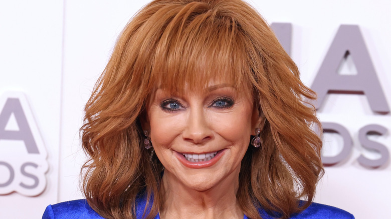 Reba McEntire smiles in a blue dress