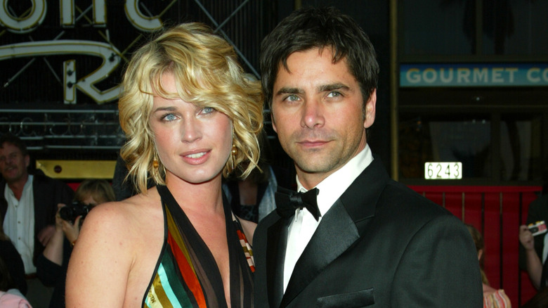 Rebecca Romijn and John Stamos posing