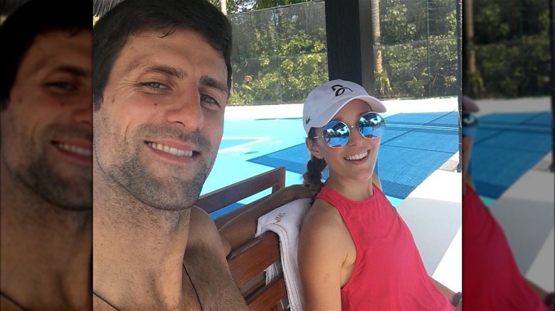 Novak and Jelena Djokovic smiling courtside