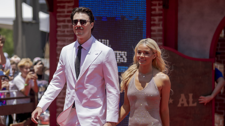 Paul Skenes and Olivia Dunne holding hands while walking outside