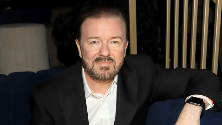 Ricky Gervais seated and smiling