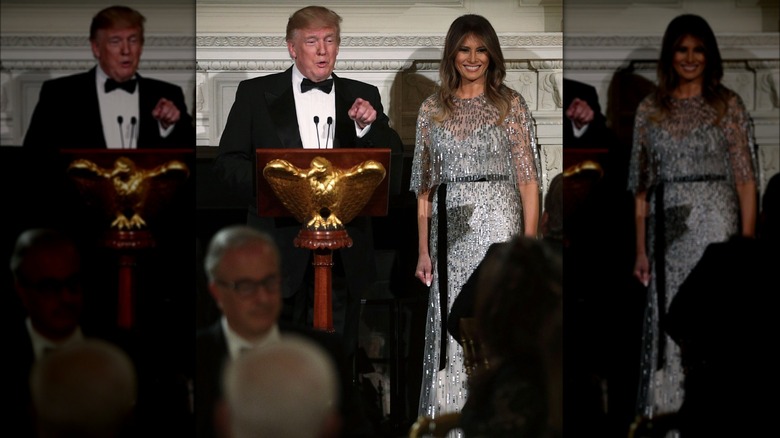 Melania Trump standing with Donald Trump making speech