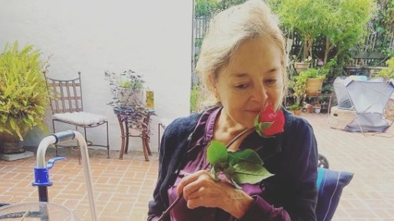 Robin Mattson enjoying the scent of a rose