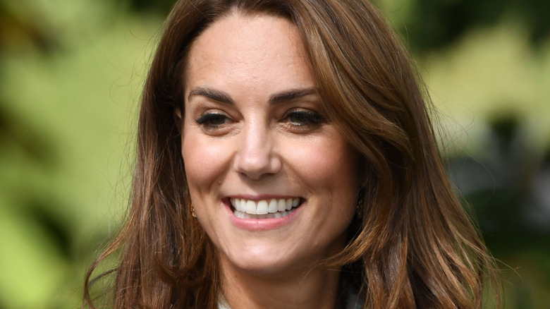 Kate Middleton smiles at an outdoor event